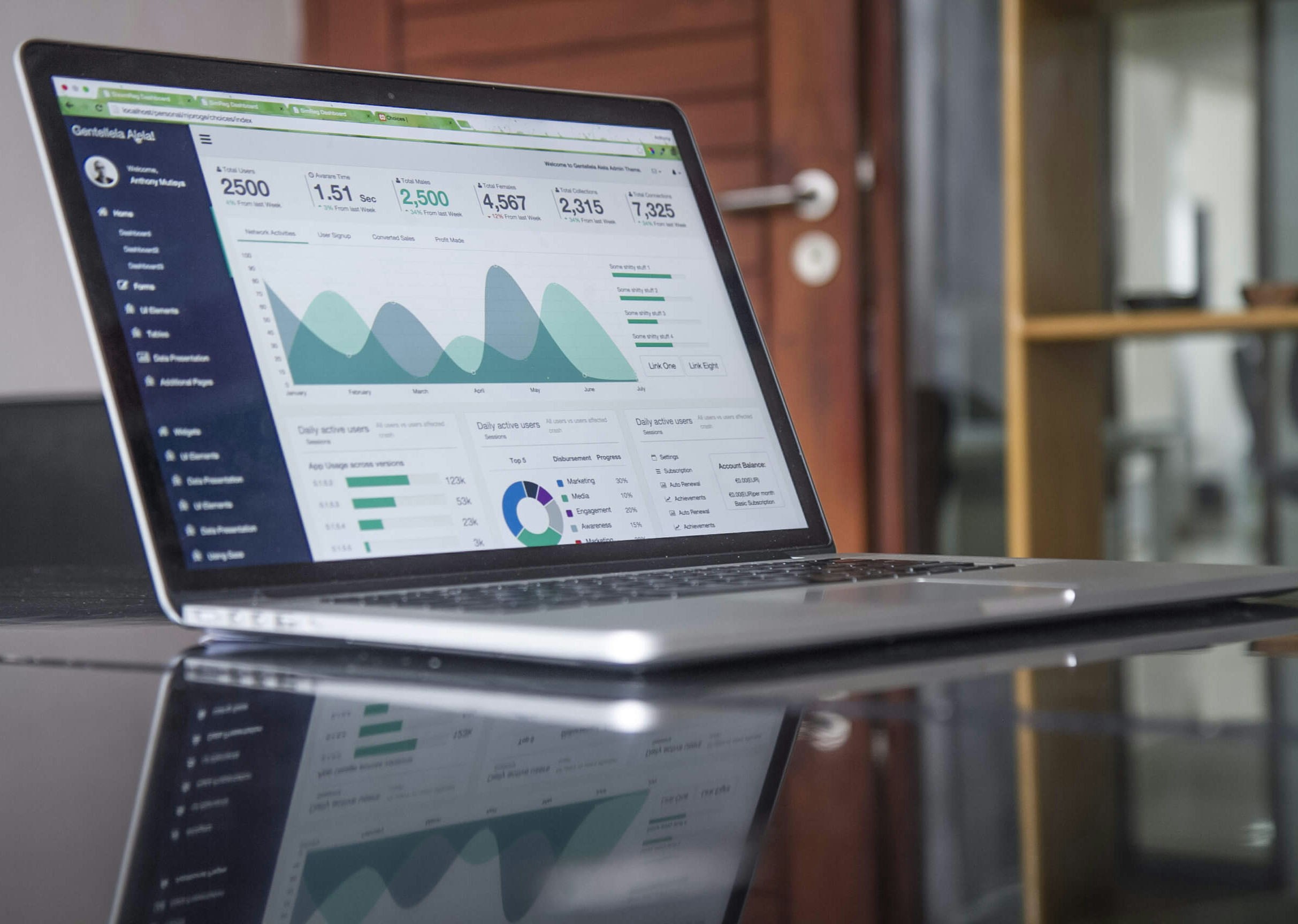 A laptop on a desk showing an invoicing dashboard